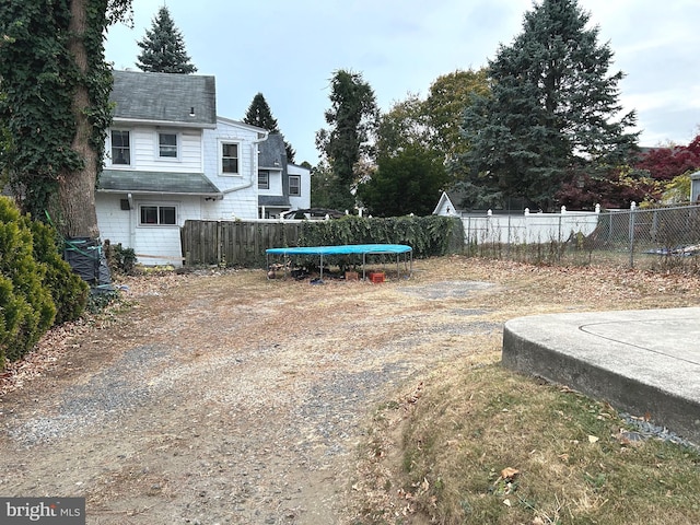 view of yard featuring a trampoline and central air condition unit