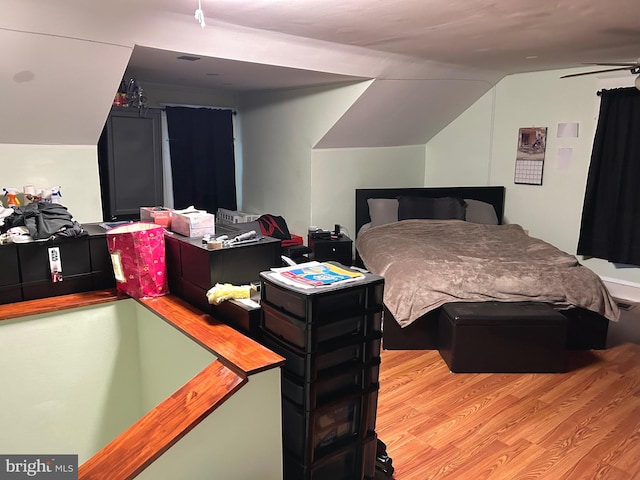 bedroom featuring lofted ceiling and light wood-type flooring