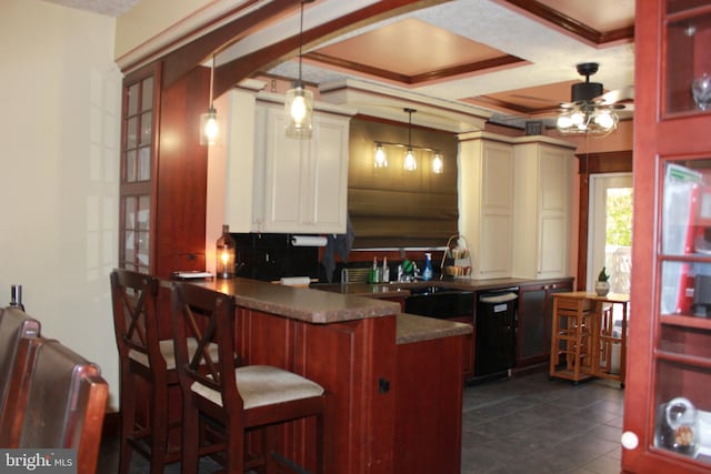 kitchen featuring ceiling fan, kitchen peninsula, pendant lighting, decorative backsplash, and a breakfast bar