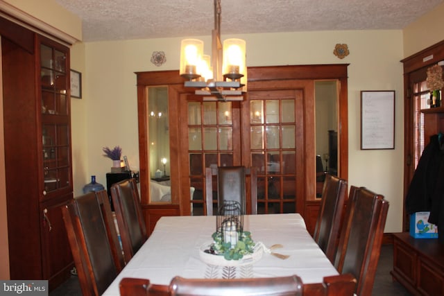 dining area with a textured ceiling and an inviting chandelier