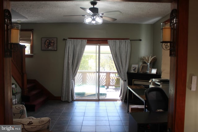 interior space featuring tile patterned floors, ceiling fan, and a textured ceiling