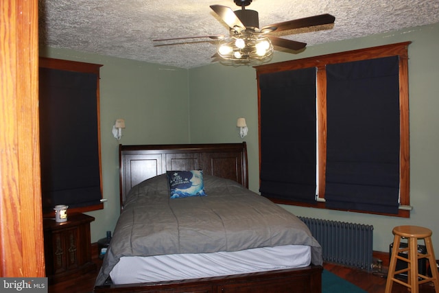 bedroom with hardwood / wood-style floors, a textured ceiling, radiator, and ceiling fan