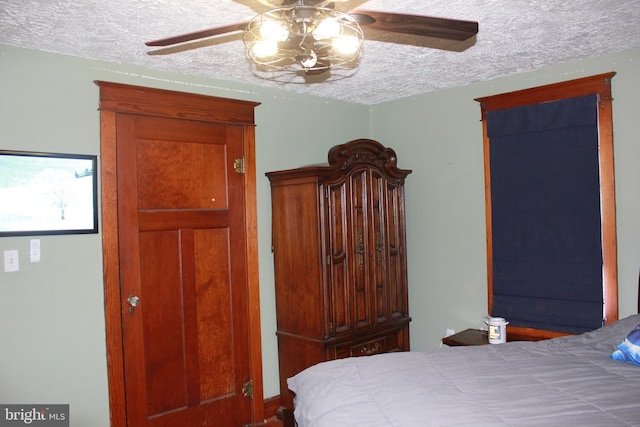 bedroom with ceiling fan and a textured ceiling