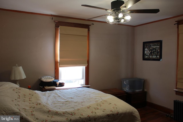 bedroom with ceiling fan, radiator heating unit, dark wood-type flooring, and ornamental molding