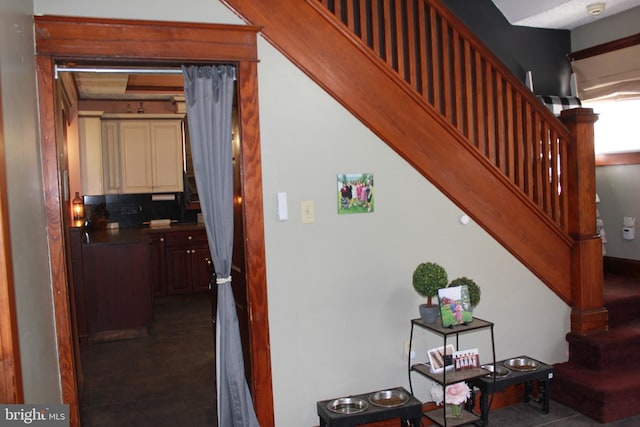 stairway featuring beamed ceiling