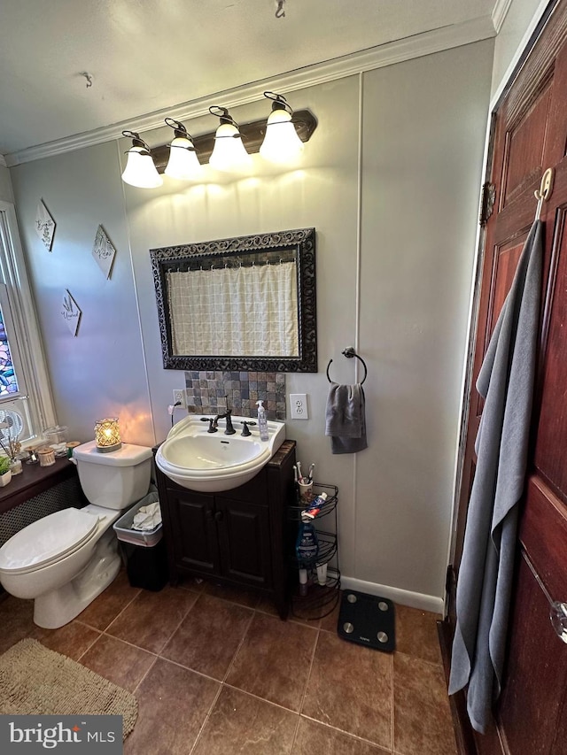 bathroom with tile patterned flooring, vanity, toilet, and crown molding