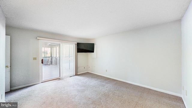 unfurnished room with carpet and a textured ceiling