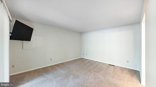 carpeted spare room with a textured ceiling