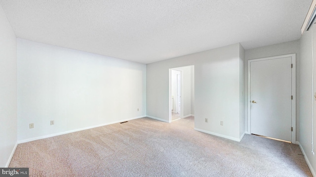 unfurnished room with light carpet and a textured ceiling