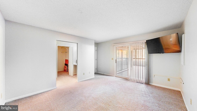 empty room featuring light carpet and a textured ceiling