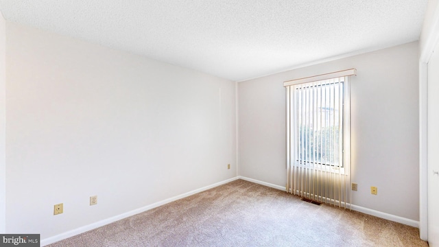 unfurnished room with carpet floors and a textured ceiling