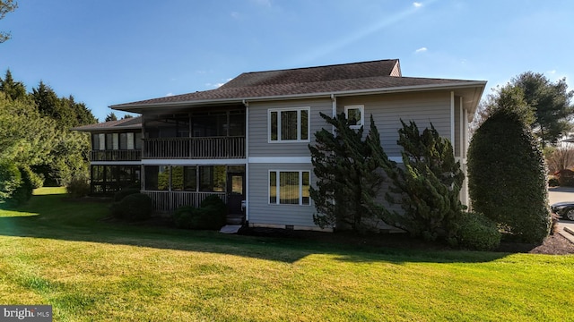 rear view of house featuring a sunroom and a yard