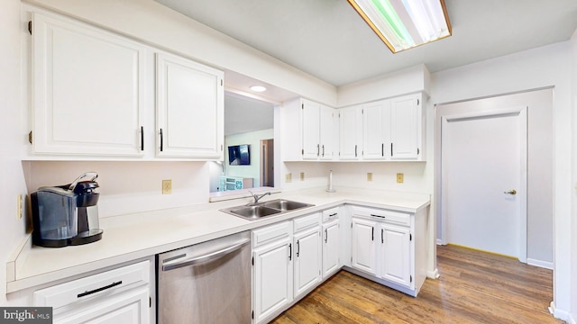 kitchen with dishwasher, hardwood / wood-style floors, white cabinets, and sink