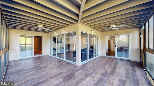 unfurnished sunroom with ceiling fan