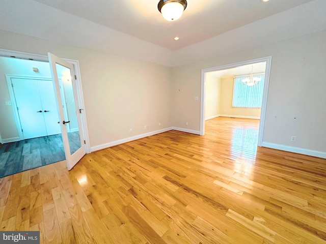 unfurnished room featuring light hardwood / wood-style flooring and an inviting chandelier