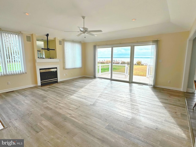 unfurnished living room featuring ceiling fan and light hardwood / wood-style flooring