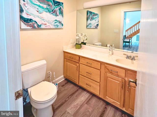 bathroom with toilet, wood-type flooring, and vanity