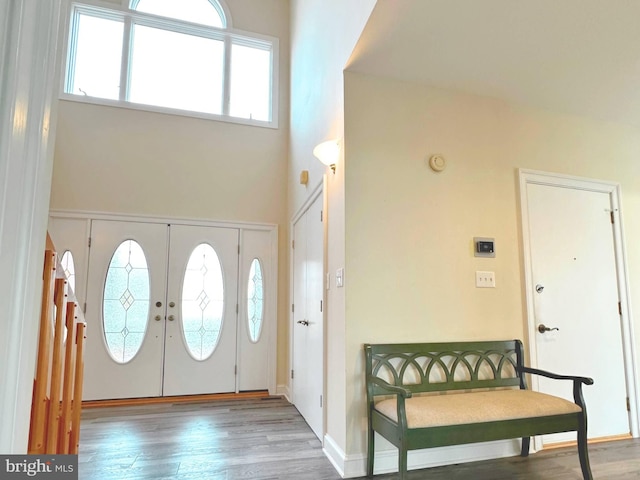 entrance foyer with hardwood / wood-style flooring, a high ceiling, and french doors