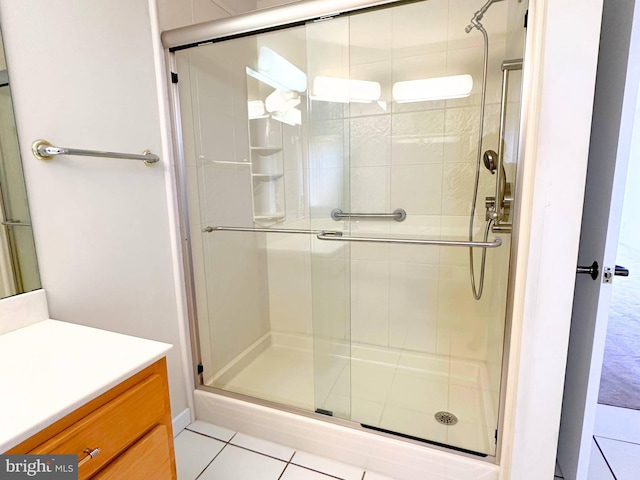 bathroom featuring walk in shower, vanity, and tile patterned flooring