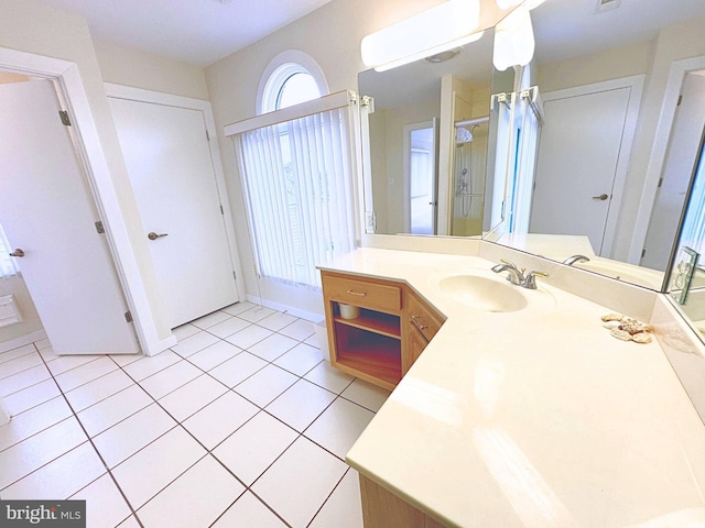 bathroom with walk in shower, vanity, and tile patterned flooring