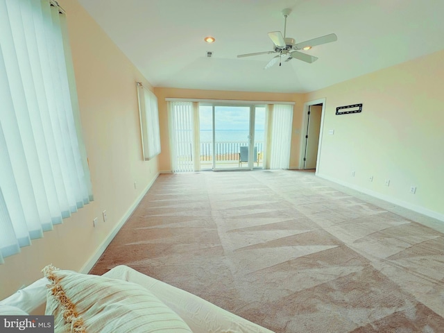 carpeted spare room with ceiling fan and lofted ceiling