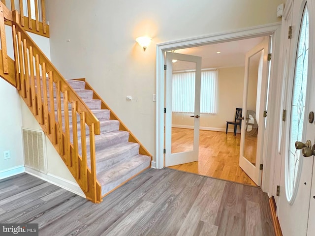 staircase with french doors and hardwood / wood-style flooring