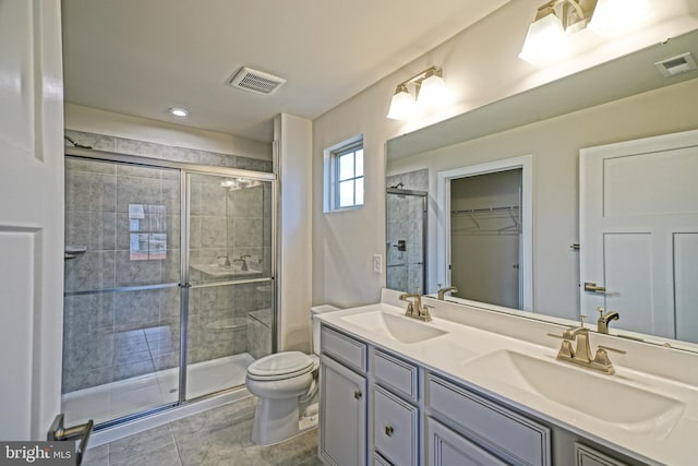 bathroom featuring tile patterned floors, a shower with door, vanity, and toilet