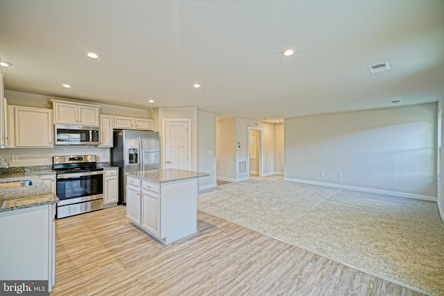 kitchen with white cabinetry, a center island, sink, and appliances with stainless steel finishes