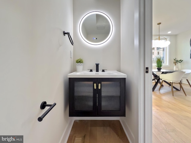 bathroom with a chandelier, hardwood / wood-style floors, and vanity