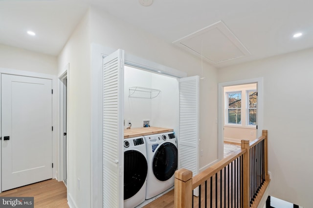 laundry area with light hardwood / wood-style floors and washer and clothes dryer