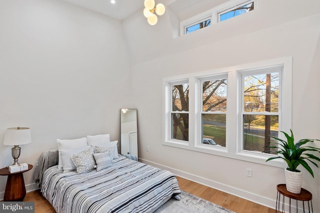 bedroom featuring hardwood / wood-style floors and a towering ceiling