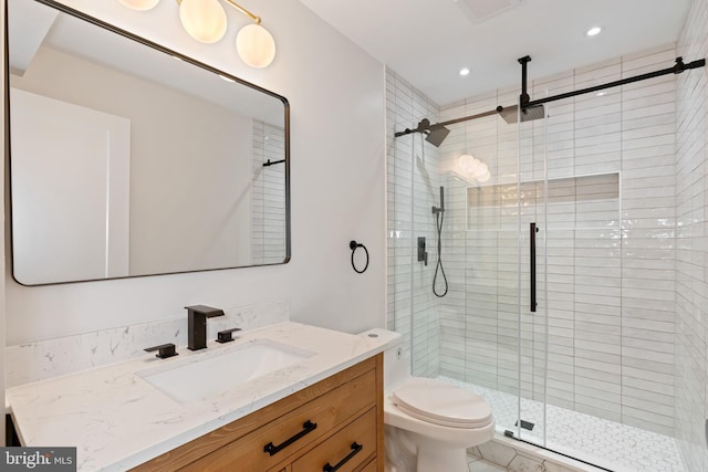 bathroom with vanity, toilet, and a shower with shower door