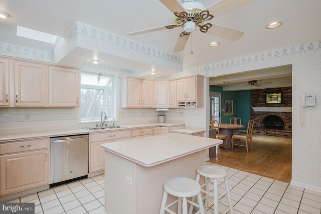 kitchen featuring dishwasher, light tile patterned floors, sink, and a breakfast bar area