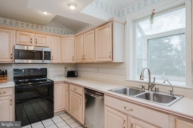 kitchen featuring a healthy amount of sunlight, sink, light tile patterned floors, and stainless steel appliances