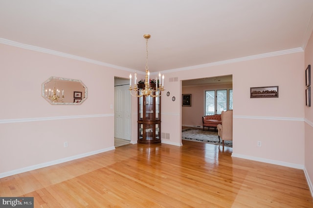 unfurnished dining area featuring hardwood / wood-style flooring, a notable chandelier, and ornamental molding