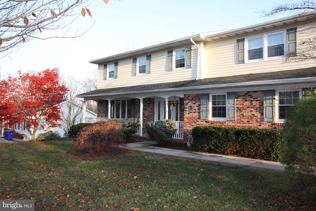 view of front of property featuring covered porch and a front lawn