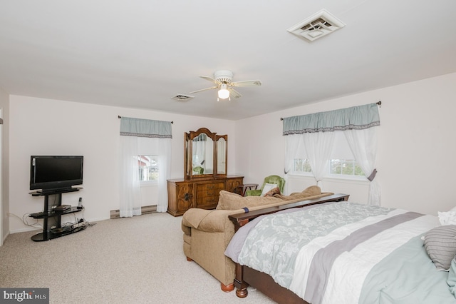 carpeted bedroom featuring multiple windows and ceiling fan