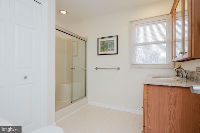 bathroom with vanity and a shower with door