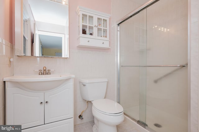 bathroom with vanity, toilet, and tile walls