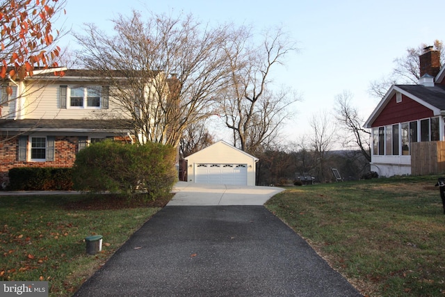 view of side of home with a sunroom, a garage, an outdoor structure, and a yard