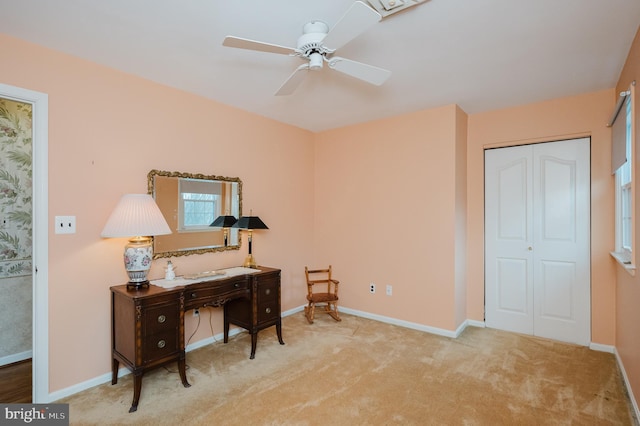 carpeted home office featuring ceiling fan