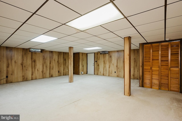 basement with wood walls and light colored carpet