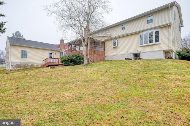 back of house with a sunroom, a yard, and a wooden deck