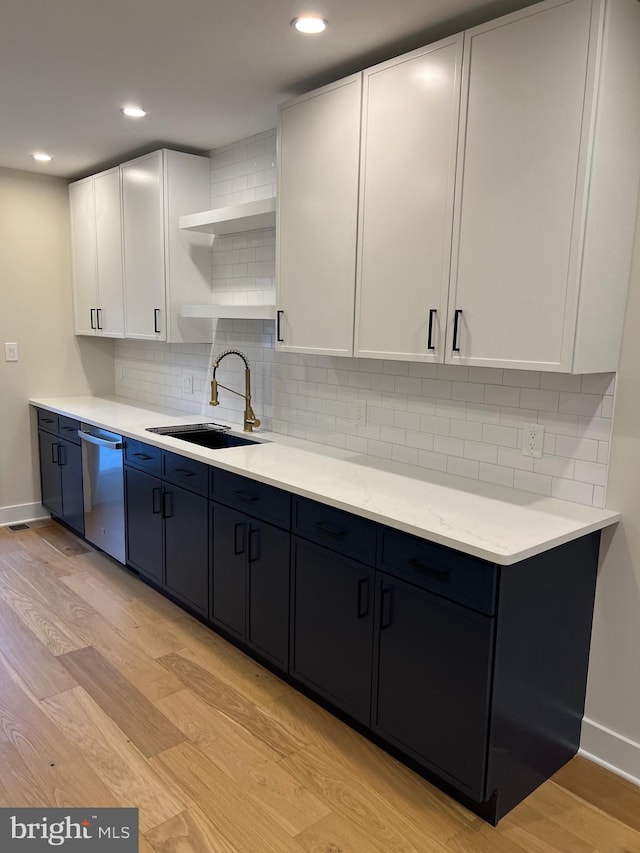 kitchen with white cabinets, dishwasher, light wood-type flooring, and sink