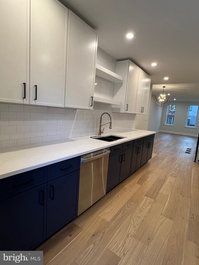 kitchen with sink, stainless steel dishwasher, a chandelier, white cabinets, and light wood-type flooring