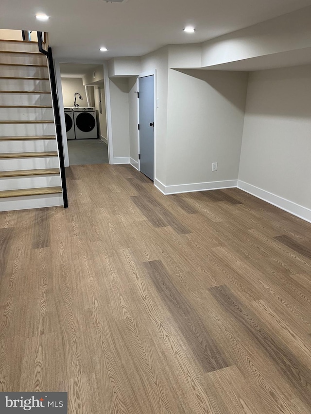 basement with wood-type flooring and washing machine and clothes dryer