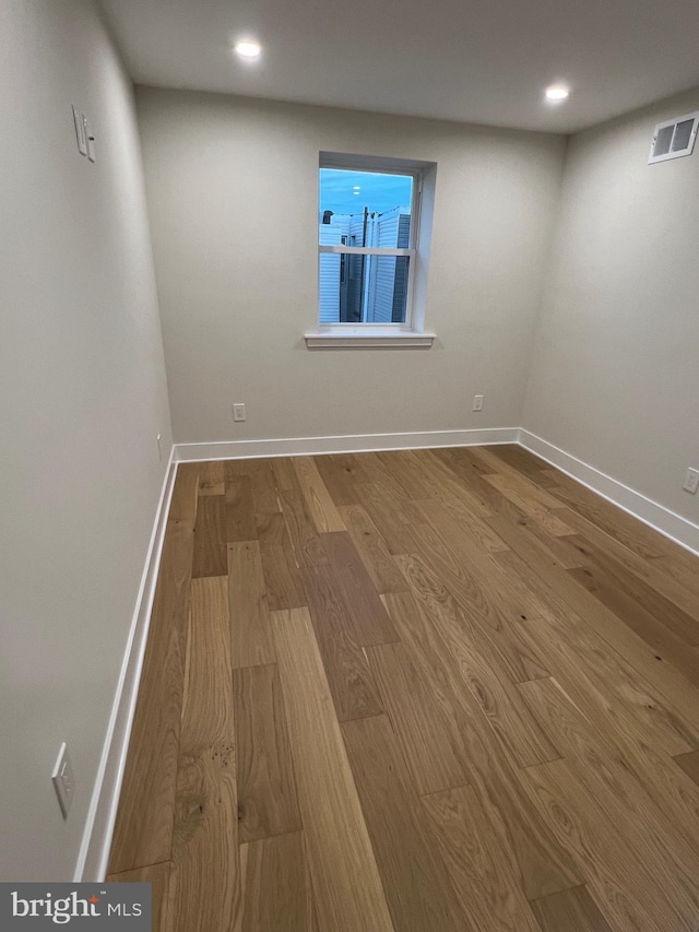 unfurnished room with hardwood / wood-style flooring