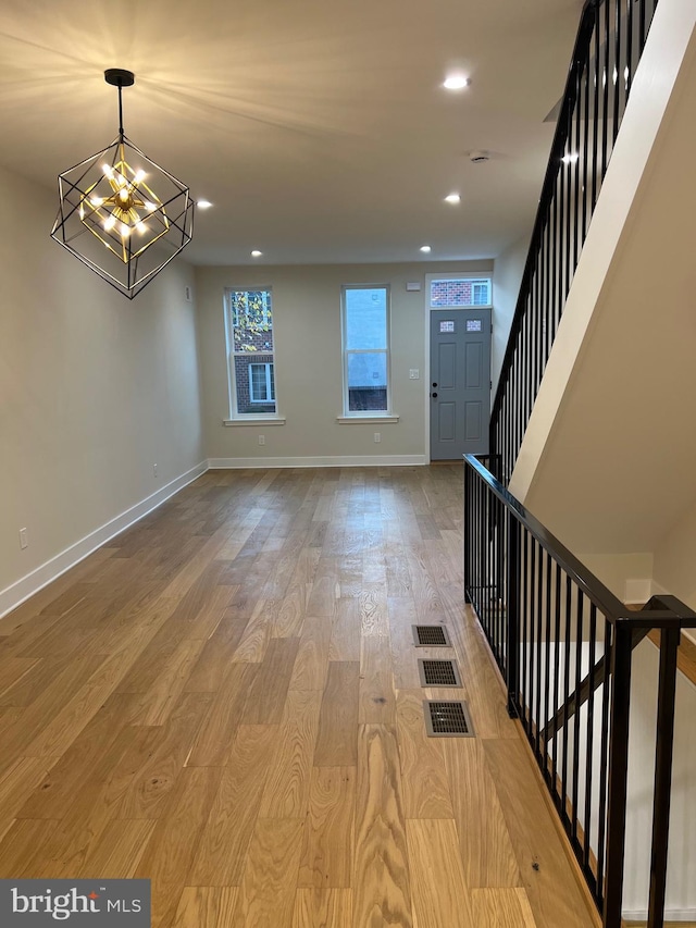 entryway with a notable chandelier and wood-type flooring