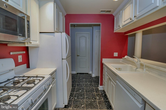 kitchen with white cabinetry, sink, and white appliances