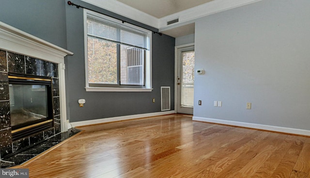 unfurnished living room featuring wood-type flooring and crown molding